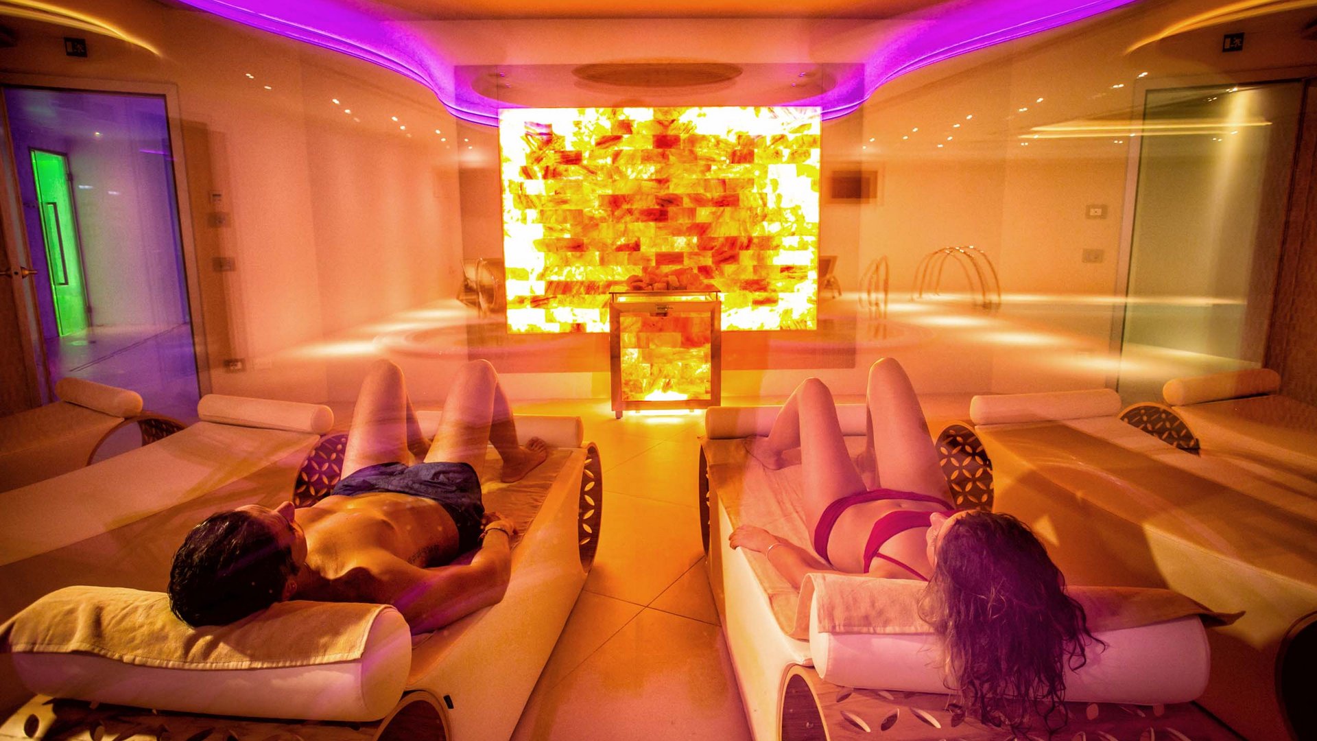 Your spa near Assisi: Assisi Cantico Spa People lying on lounge chairs in a spa with warm ambient lighting