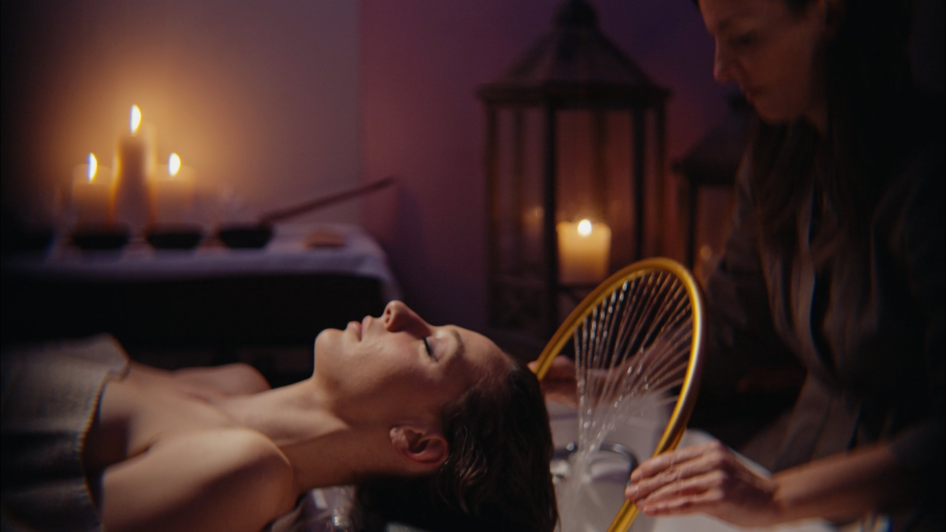 Donna che riceve trattamento spa per capelli in ambiente rilassante con candele
