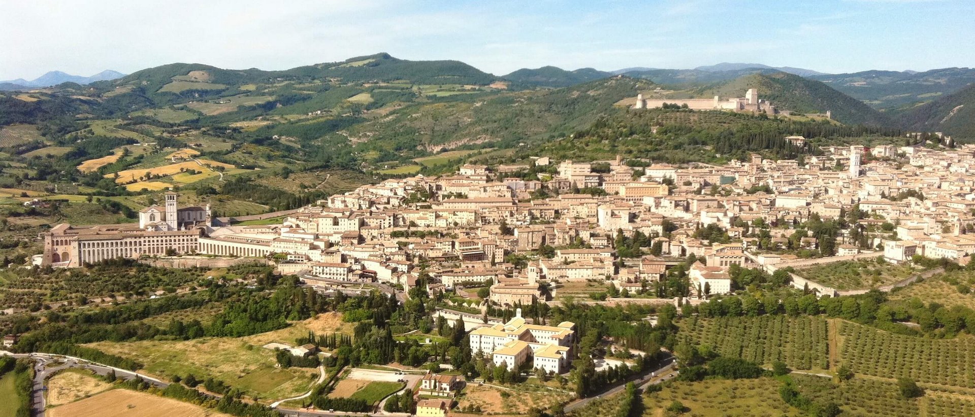 Basilica of Saint Francis of Assisi Aerial view of Assisi with fields and hills in Umbria