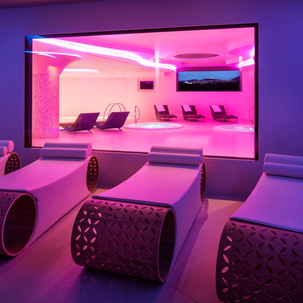Your spa near Assisi: Assisi Cantico Spa Modern spa interior with lounge chairs and pink neon lighting
